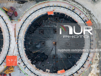 Workers work at the construction site of the first phase of the Hualian grain storage and logistics project at Huangma Port in Huaian City,...