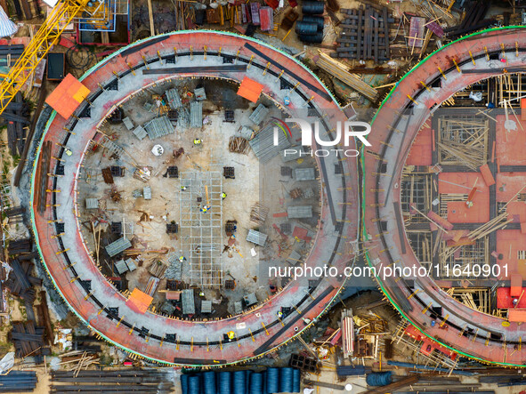 Workers work at the construction site of the first phase of the Hualian grain storage and logistics project at Huangma Port in Huaian City,...