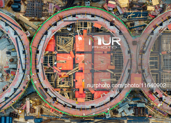 Workers work at the construction site of the first phase of the Hualian grain storage and logistics project at Huangma Port in Huaian City,...