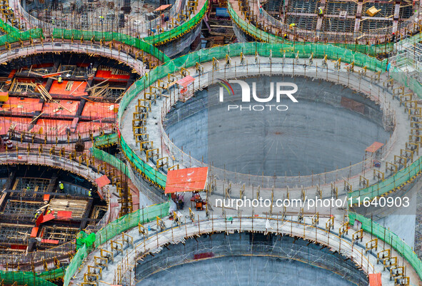 Workers work at the construction site of the first phase of the Hualian grain storage and logistics project at Huangma Port in Huaian City,...