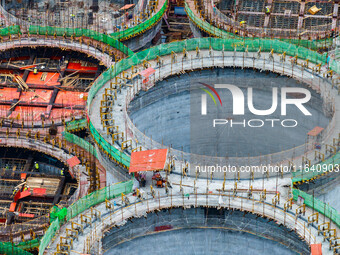 Workers work at the construction site of the first phase of the Hualian grain storage and logistics project at Huangma Port in Huaian City,...