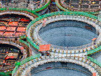 Workers work at the construction site of the first phase of the Hualian grain storage and logistics project at Huangma Port in Huaian City,...