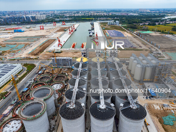 Workers work at the construction site of the first phase of the Hualian grain storage and logistics project at Huangma Port in Huaian City,...