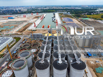 Workers work at the construction site of the first phase of the Hualian grain storage and logistics project at Huangma Port in Huaian City,...