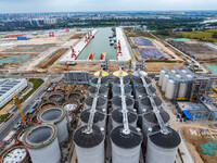 Workers work at the construction site of the first phase of the Hualian grain storage and logistics project at Huangma Port in Huaian City,...