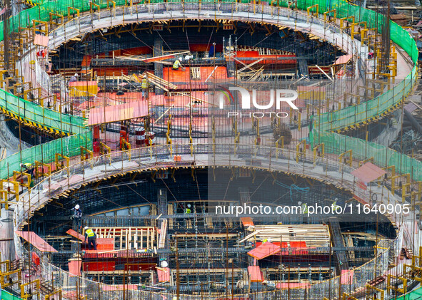 Workers work at the construction site of the first phase of the Hualian grain storage and logistics project at Huangma Port in Huaian City,...