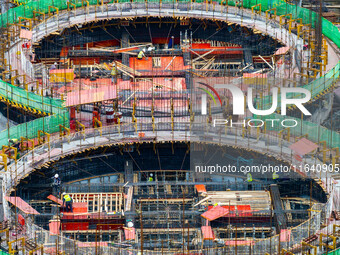 Workers work at the construction site of the first phase of the Hualian grain storage and logistics project at Huangma Port in Huaian City,...