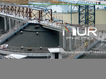 Workers work at the construction site of the first phase of the Hualian grain storage and logistics project at Huangma Port in Huaian City,...