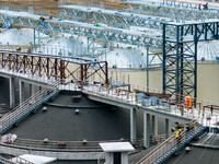 Workers work at the construction site of the first phase of the Hualian grain storage and logistics project at Huangma Port in Huaian City,...