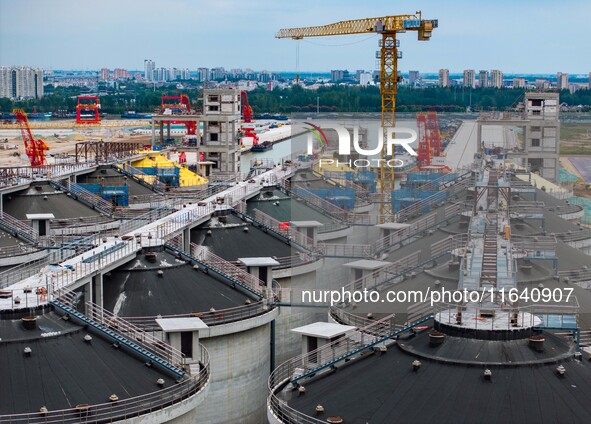 Workers work at the construction site of the first phase of the Hualian grain storage and logistics project at Huangma Port in Huaian City,...