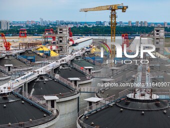 Workers work at the construction site of the first phase of the Hualian grain storage and logistics project at Huangma Port in Huaian City,...