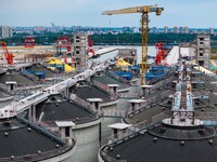 Workers work at the construction site of the first phase of the Hualian grain storage and logistics project at Huangma Port in Huaian City,...