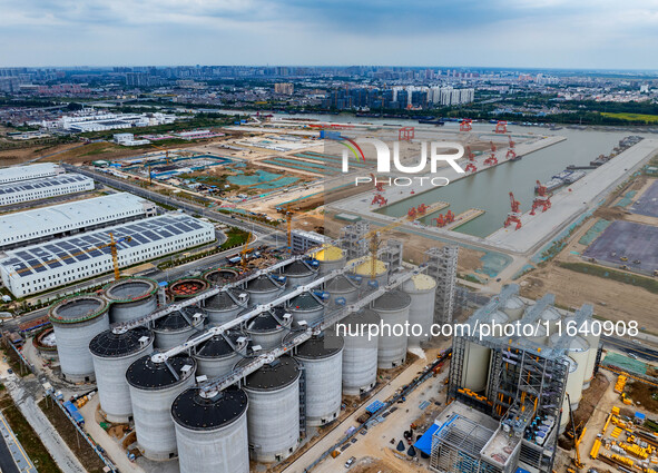 Workers work at the construction site of the first phase of the Hualian grain storage and logistics project at Huangma Port in Huaian City,...