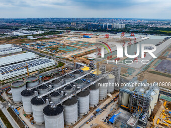 Workers work at the construction site of the first phase of the Hualian grain storage and logistics project at Huangma Port in Huaian City,...