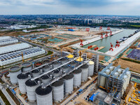 Workers work at the construction site of the first phase of the Hualian grain storage and logistics project at Huangma Port in Huaian City,...