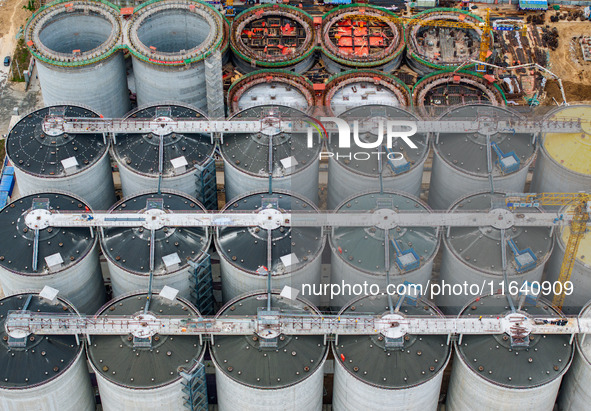 Workers work at the construction site of the first phase of the Hualian grain storage and logistics project at Huangma Port in Huaian City,...