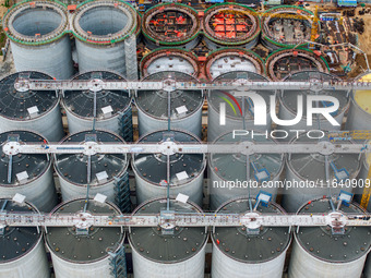 Workers work at the construction site of the first phase of the Hualian grain storage and logistics project at Huangma Port in Huaian City,...