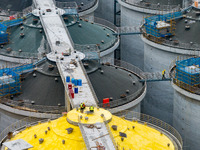 Workers work at the construction site of the first phase of the Hualian grain storage and logistics project at Huangma Port in Huaian City,...