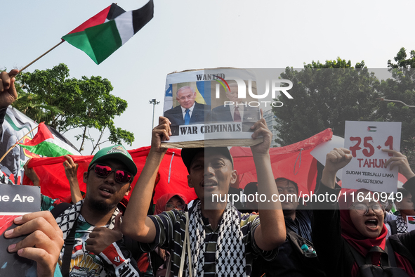 A pro-Palestinian demonstrator holds a poster with photos of Israeli Prime Minister Benjamin Netanyahu and US President Joe Biden during a p...