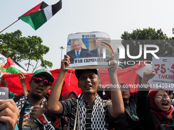 A pro-Palestinian demonstrator holds a poster with photos of Israeli Prime Minister Benjamin Netanyahu and US President Joe Biden during a p...