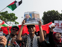 A pro-Palestinian demonstrator holds a poster with photos of Israeli Prime Minister Benjamin Netanyahu and US President Joe Biden during a p...