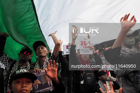 Pro-Palestinian demonstrators unfurl Palestinian flags during a protest marking the one-year anniversary of the Israel-Hamas conflict in fro...