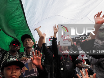 Pro-Palestinian demonstrators unfurl Palestinian flags during a protest marking the one-year anniversary of the Israel-Hamas conflict in fro...