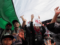 Pro-Palestinian demonstrators unfurl Palestinian flags during a protest marking the one-year anniversary of the Israel-Hamas conflict in fro...