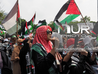 Pro-Palestinian demonstrators hold a protest marking the one-year anniversary of the Israel-Hamas conflict in front of the US Embassy in Jak...