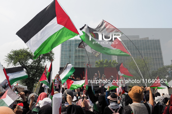 Pro-Palestinian demonstrators carry Palestinian flags during a protest marking the one-year anniversary of the Israel-Hamas conflict in fron...