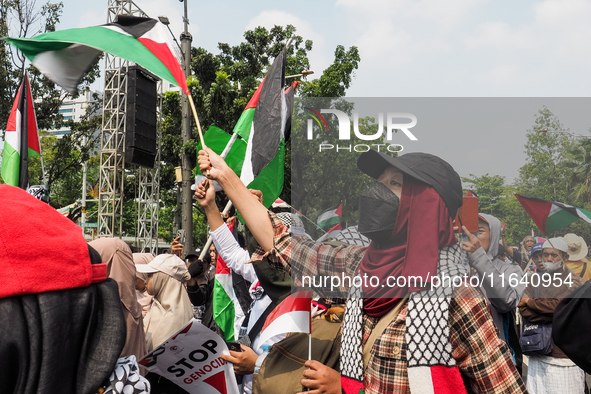 Pro-Palestinian demonstrators carry Palestinian flags during a protest marking the one-year anniversary of the Israel-Hamas conflict in fron...