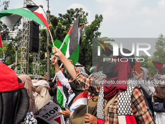 Pro-Palestinian demonstrators carry Palestinian flags during a protest marking the one-year anniversary of the Israel-Hamas conflict in fron...