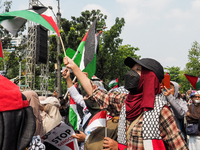 Pro-Palestinian demonstrators carry Palestinian flags during a protest marking the one-year anniversary of the Israel-Hamas conflict in fron...