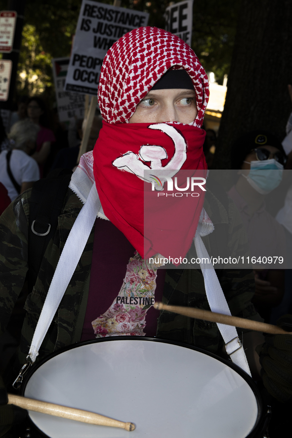 A person poses for photographs during a pro-Palestinian rally as part of an international day of action near the White House in Washington D...