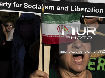 A person shows an Iranian flag during a pro-Palestinian rally as part of an international day of action near the White House in Washington D...