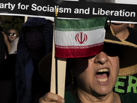 A person shows an Iranian flag during a pro-Palestinian rally as part of an international day of action near the White House in Washington D...