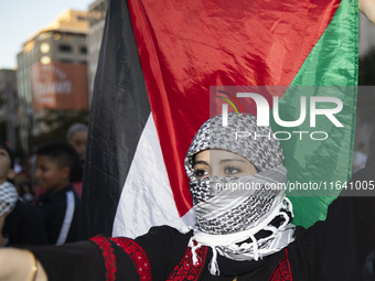 A person poses for photographs during a pro-Palestinian rally as part of an international day of action near the White House in Washington D...