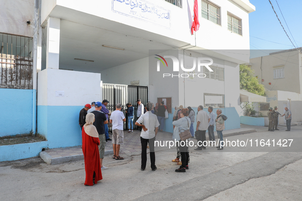 Tunisian voters queue as they await the opening of the polling station to cast their vote during the presidential election in Ariana, a subu...