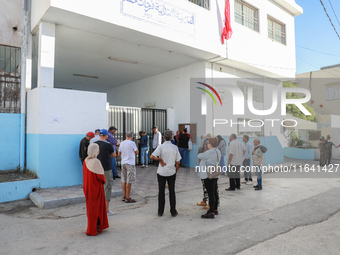 Tunisian voters queue as they await the opening of the polling station to cast their vote during the presidential election in Ariana, a subu...