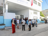 Tunisian voters queue as they await the opening of the polling station to cast their vote during the presidential election in Ariana, a subu...