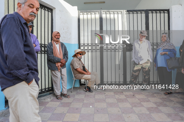 Tunisian voters queue as they await the opening of the polling station to cast their vote during the presidential election in Ariana, a subu...