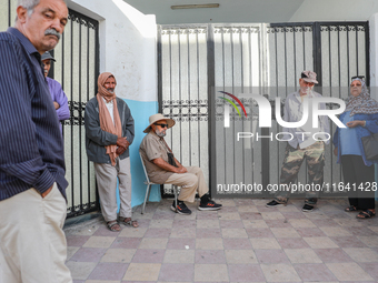 Tunisian voters queue as they await the opening of the polling station to cast their vote during the presidential election in Ariana, a subu...