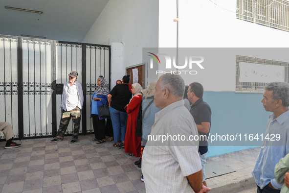 Tunisian voters queue as they await the opening of the polling station to cast their vote during the presidential election in Ariana, a subu...