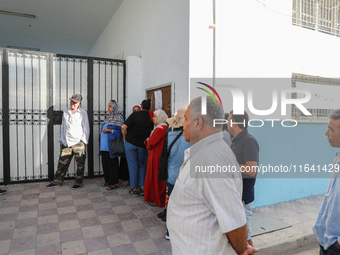 Tunisian voters queue as they await the opening of the polling station to cast their vote during the presidential election in Ariana, a subu...