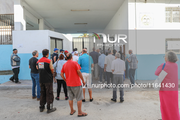 Tunisian voters queue as they await the opening of the polling station to cast their vote during the presidential election in Ariana, a subu...