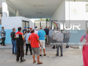 Tunisian voters queue as they await the opening of the polling station to cast their vote during the presidential election in Ariana, a subu...