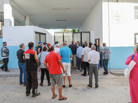 Tunisian voters queue as they await the opening of the polling station to cast their vote during the presidential election in Ariana, a subu...