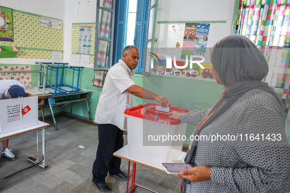 A Tunisian man casts his ballot at a polling station during the presidential election in Ariana, a suburb of Tunis, Tunisia, on October 6, 2...