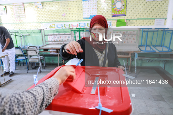 A Tunisian woman casts her ballot at a polling station during the presidential election in Ariana, a suburb of Tunis, Tunisia, on October 6,...