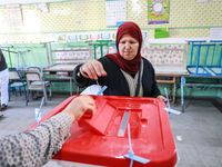 A Tunisian woman casts her ballot at a polling station during the presidential election in Ariana, a suburb of Tunis, Tunisia, on October 6,...